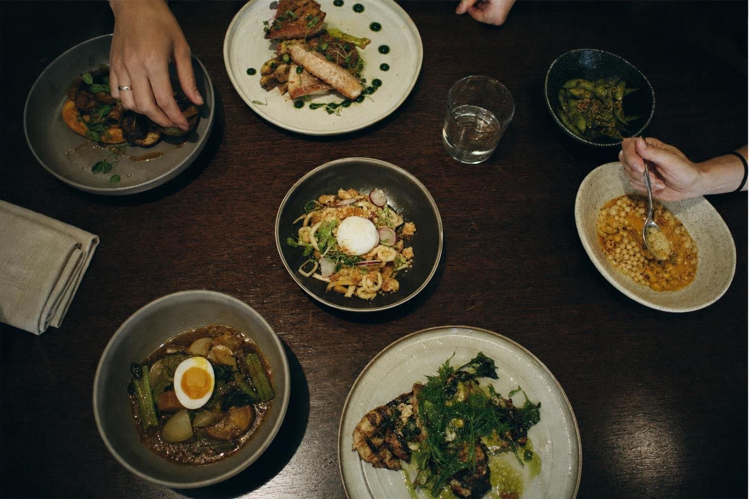 An overhead flat lay of several restaurant dishes on a table
